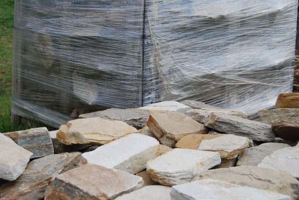 Ivory White Quartzite Cladding — split-face quartzite, stacked on a pallet with loose pieces in front