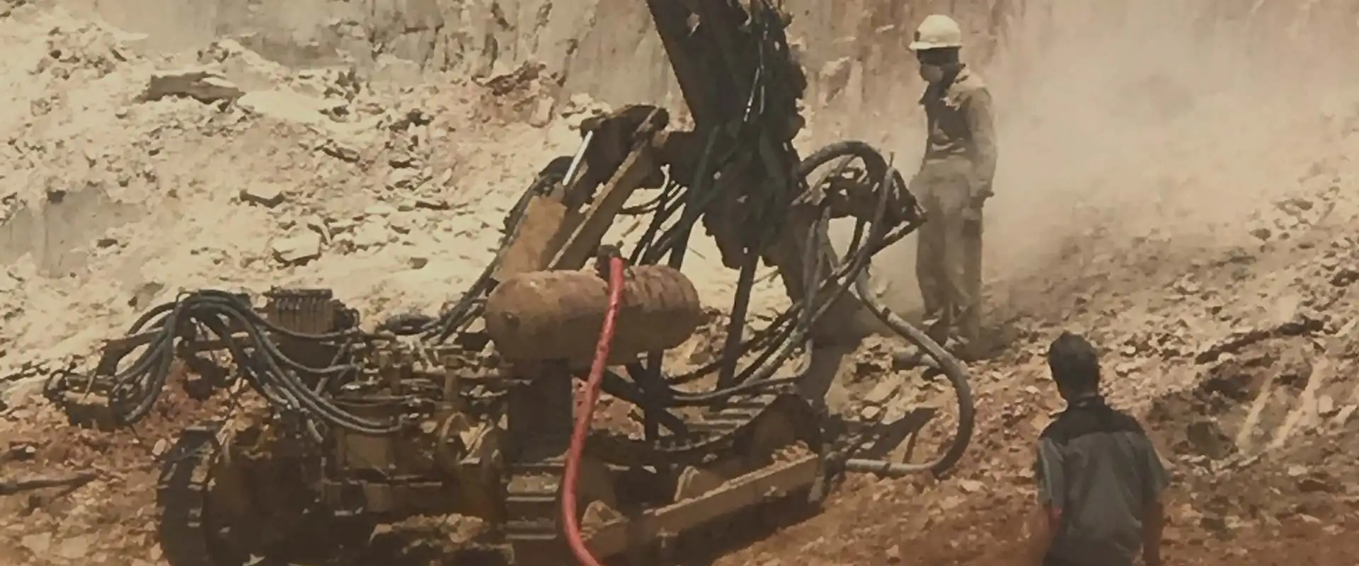Drilling rig working a bench at the quarry face
